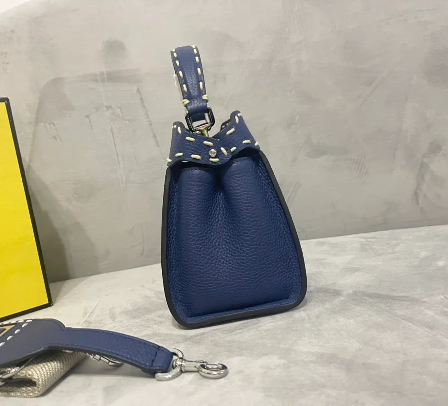 Синяя кожаная сумка с контрастным швом, вид сбоку
