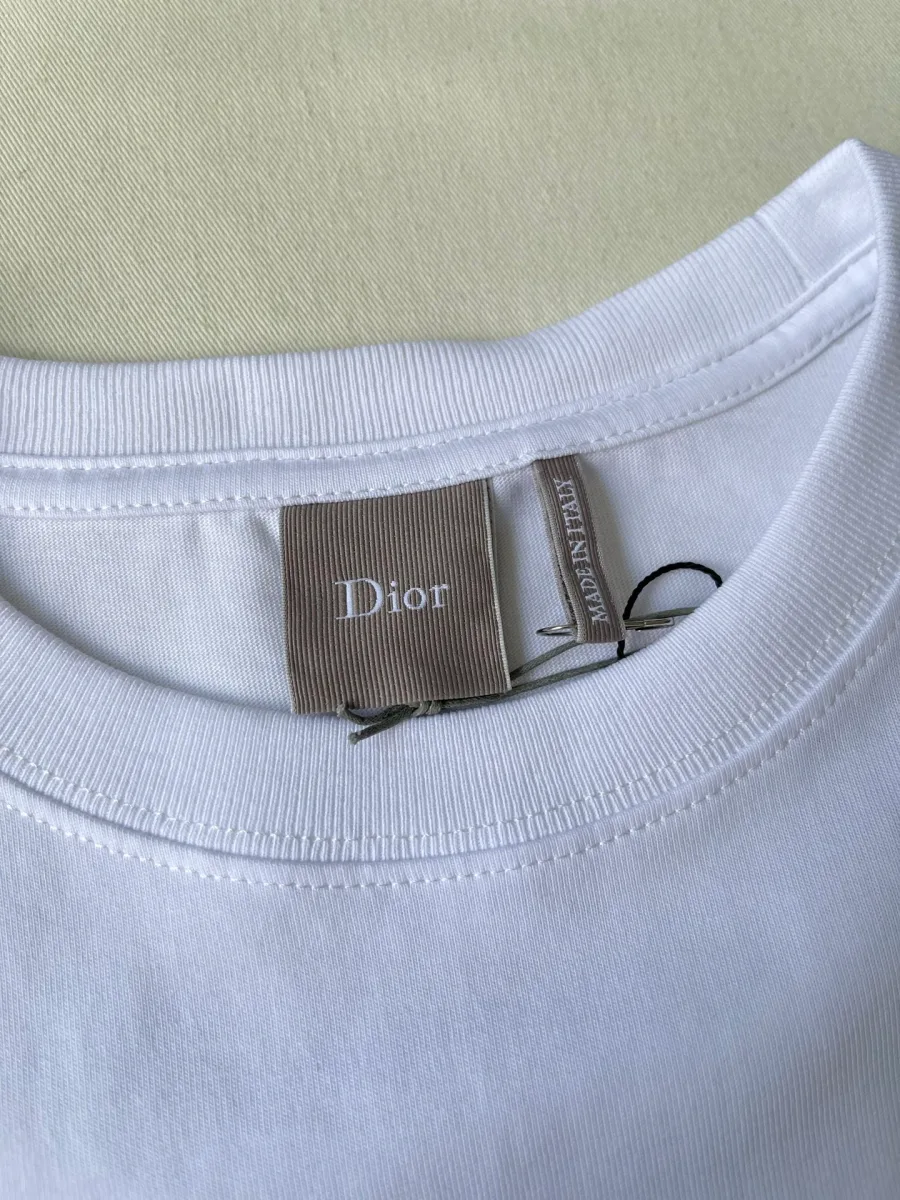 Внутренняя тканевая бирка с логотипом Dior на горловине футболки