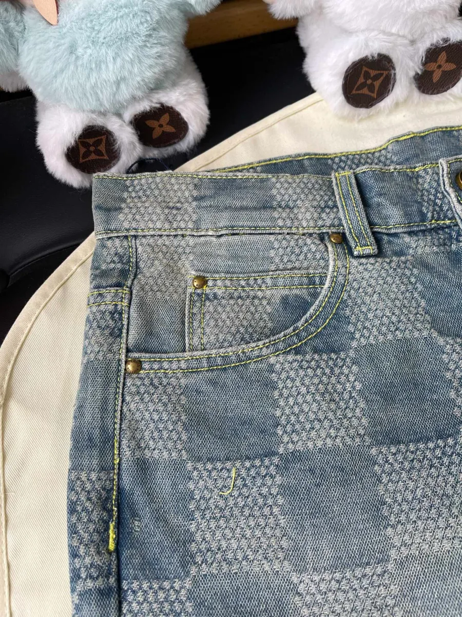 Крупный план переднего кармана джинсов с заклёпками и узором Damier