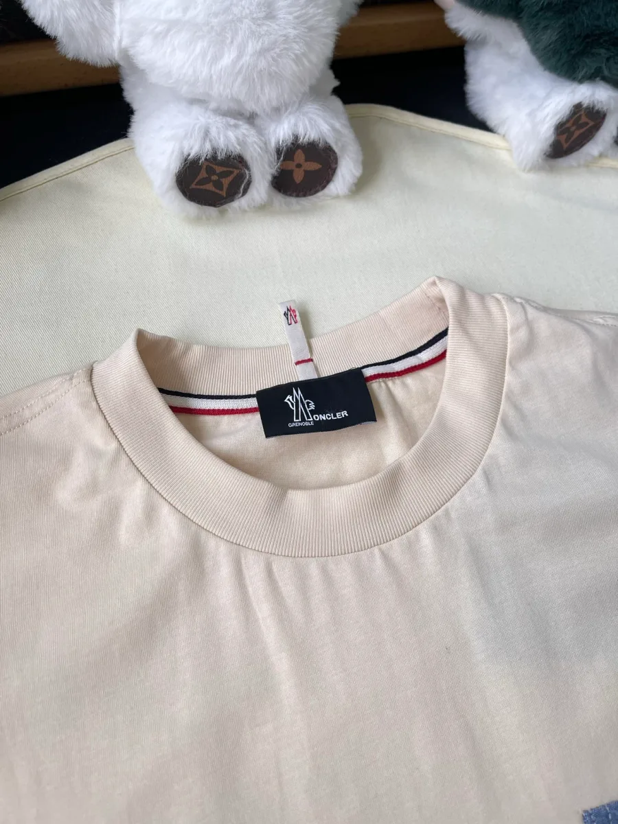 Круглый воротник футболки с биркой Moncler и триколорной тесьмой