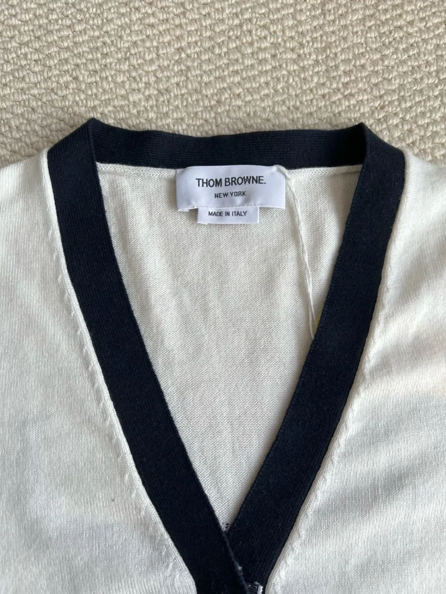 Деталь V-образного выреза горловины и ярлык Thom Browne на внутренней стороне