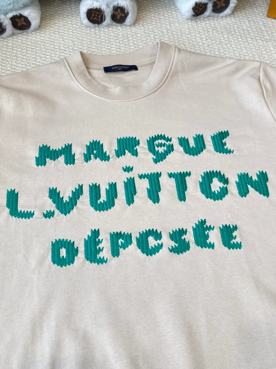 Деталь объёмной зелёной вышивки Marque L.Vuitton Déposée на груди