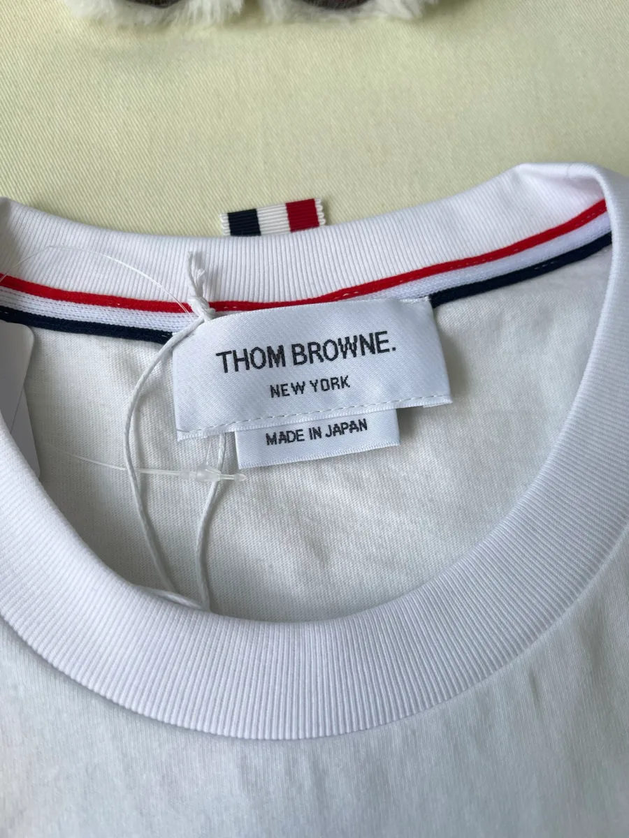 Фирменный тканый ярлык бренда Thom Browne New York на внутренней стороне горловины
