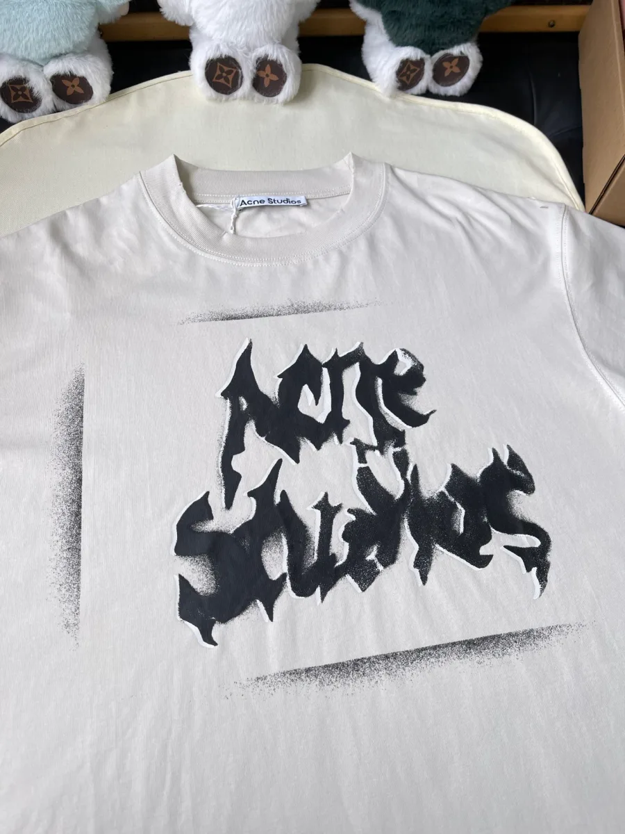 Крупный план готического логотипа Acne Studios на груди