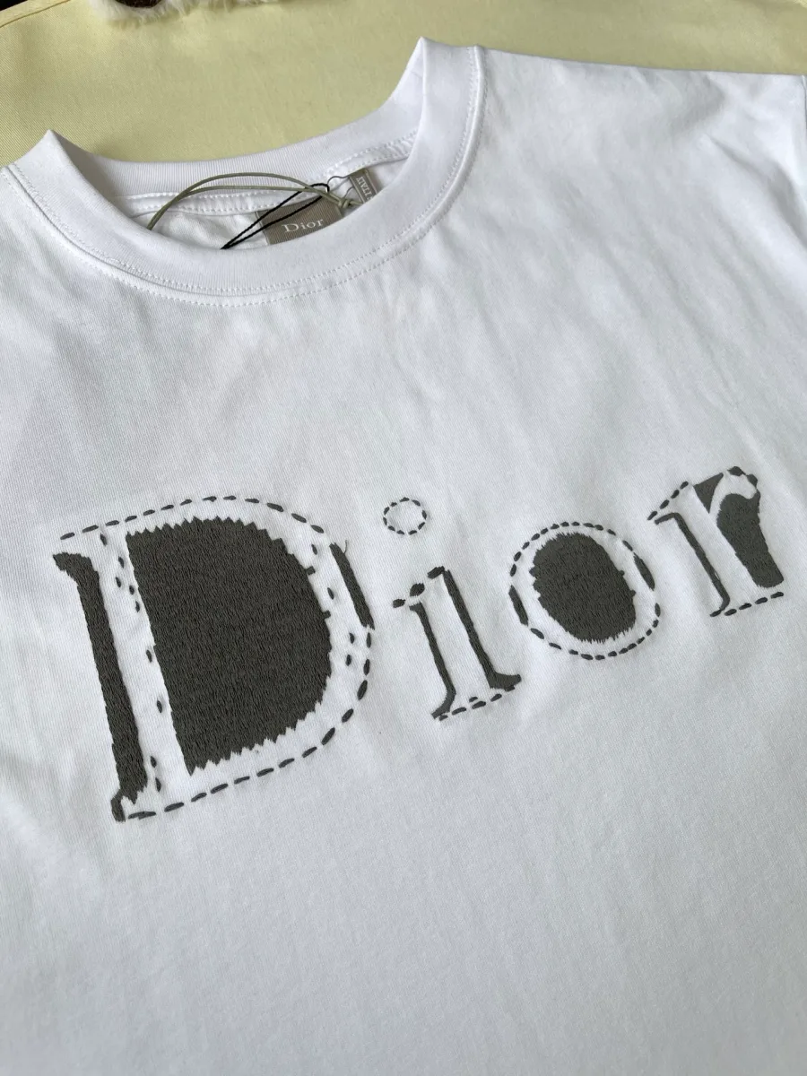 Крупный план вышитого логотипа Dior с контрастной пунктирной отделкой