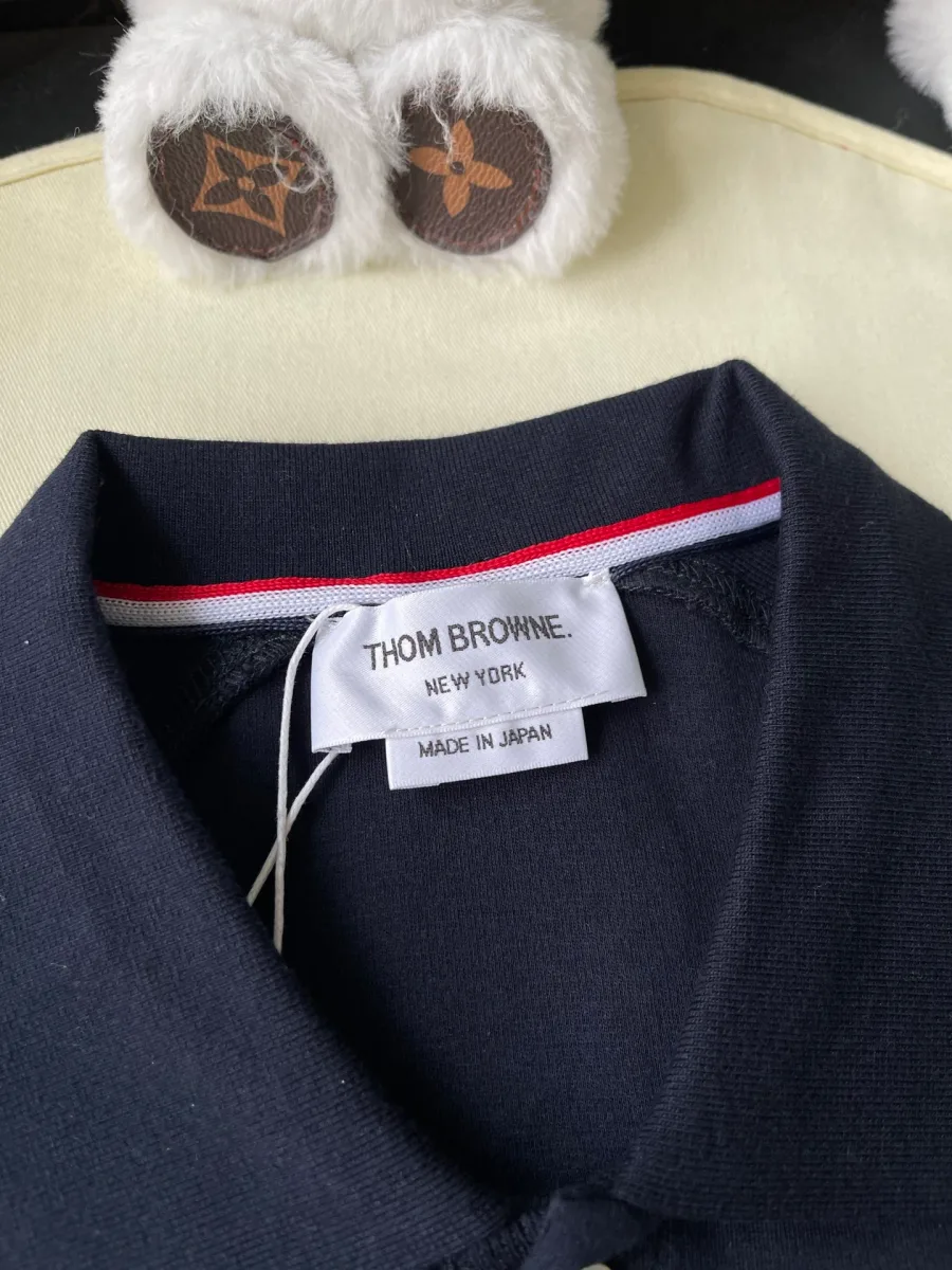 Внутренняя бирка Thom Browne на воротнике с трёхцветной петлёй