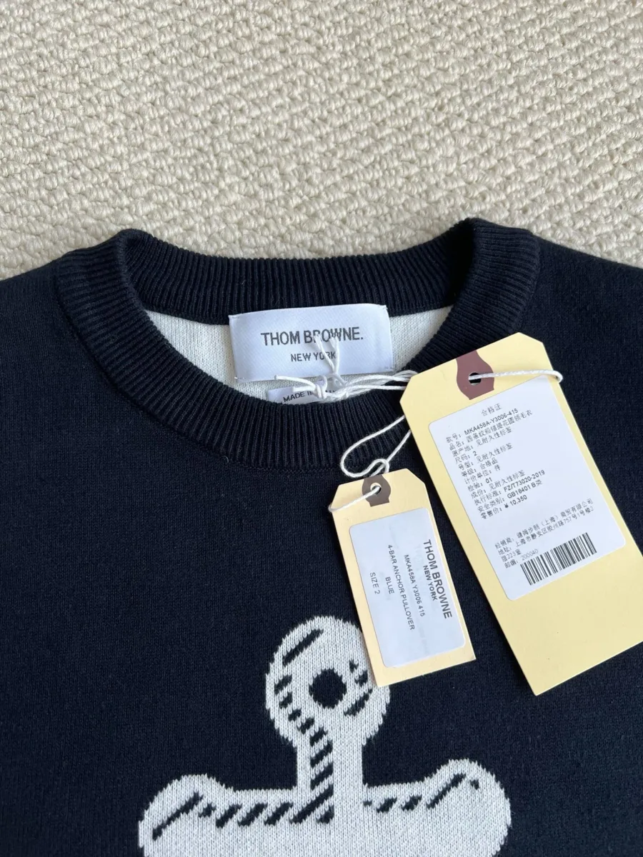 Круглая горловина тёмно-синего джемпера с биркой Thom Browne и навесными ярлыками