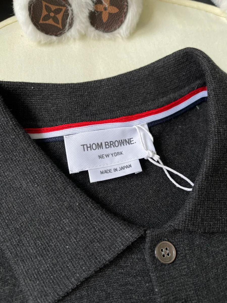 Фирменная бирка Thom Browne и трёхцветная полосатая тесьма на горловине поло