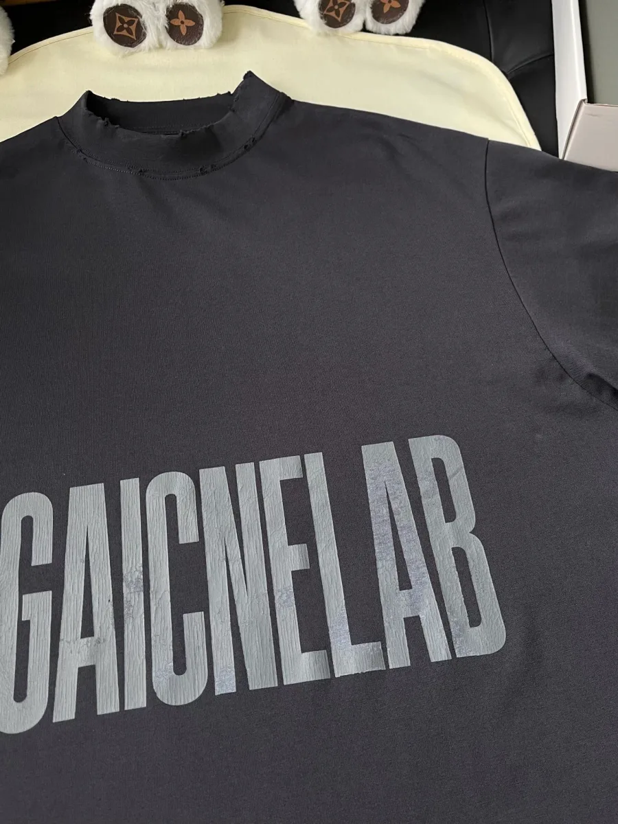 Крупный план принта AGAICNELAB на груди футболки