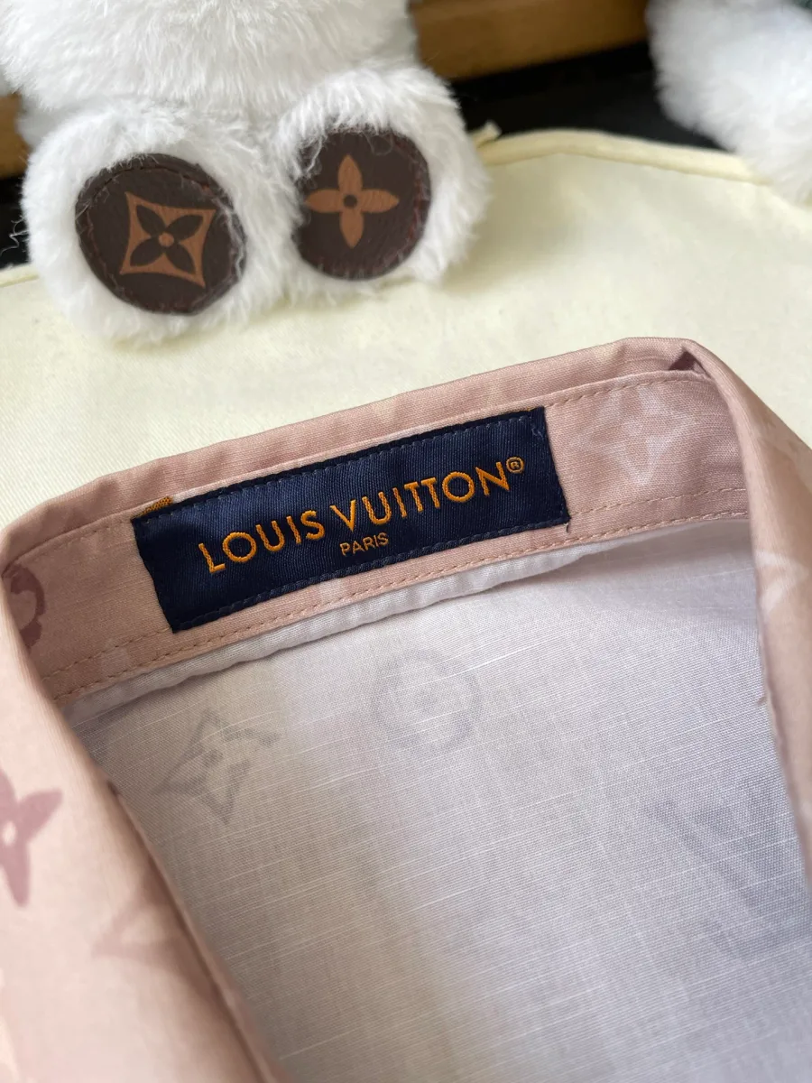 Крупный план тканой фирменной бирки Louis Vuitton на внутренней стойке воротника