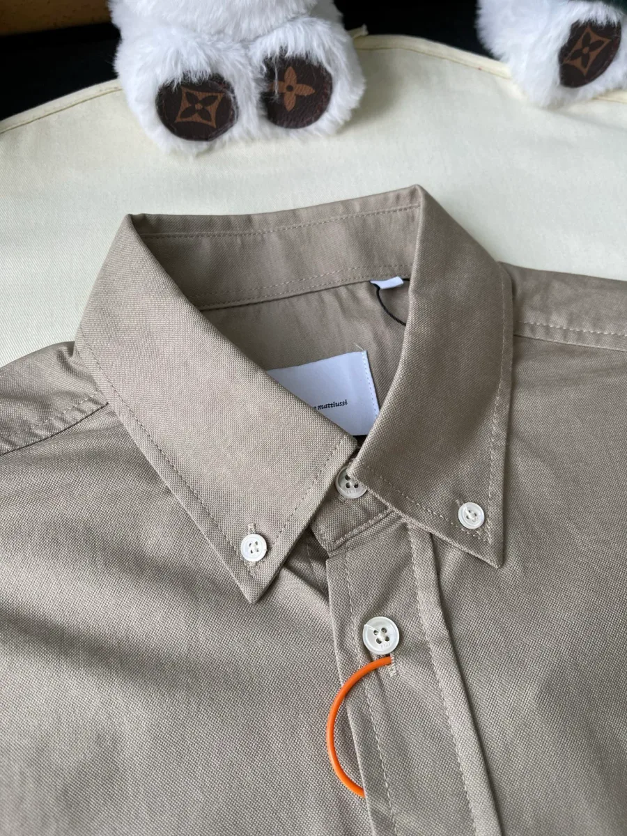 Воротник button-down бежевой рубашки крупным планом