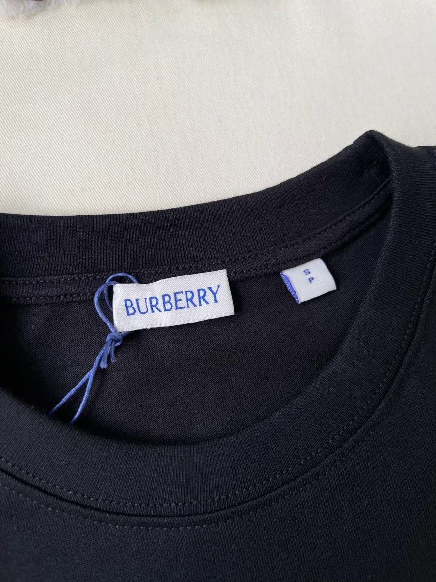 Крупный план фирменной тканевой бирки Burberry на внутренней стороне горловины