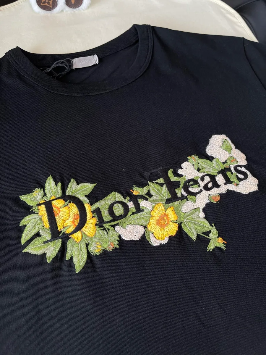 Вышитый логотип Dior Tears с цветками на груди футболки крупным планом