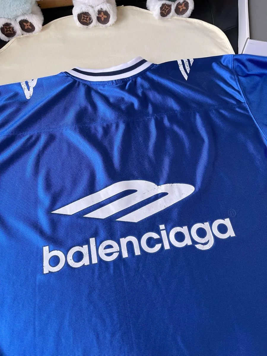 Белый принт Balenciaga на спинке синей футболки крупным планом