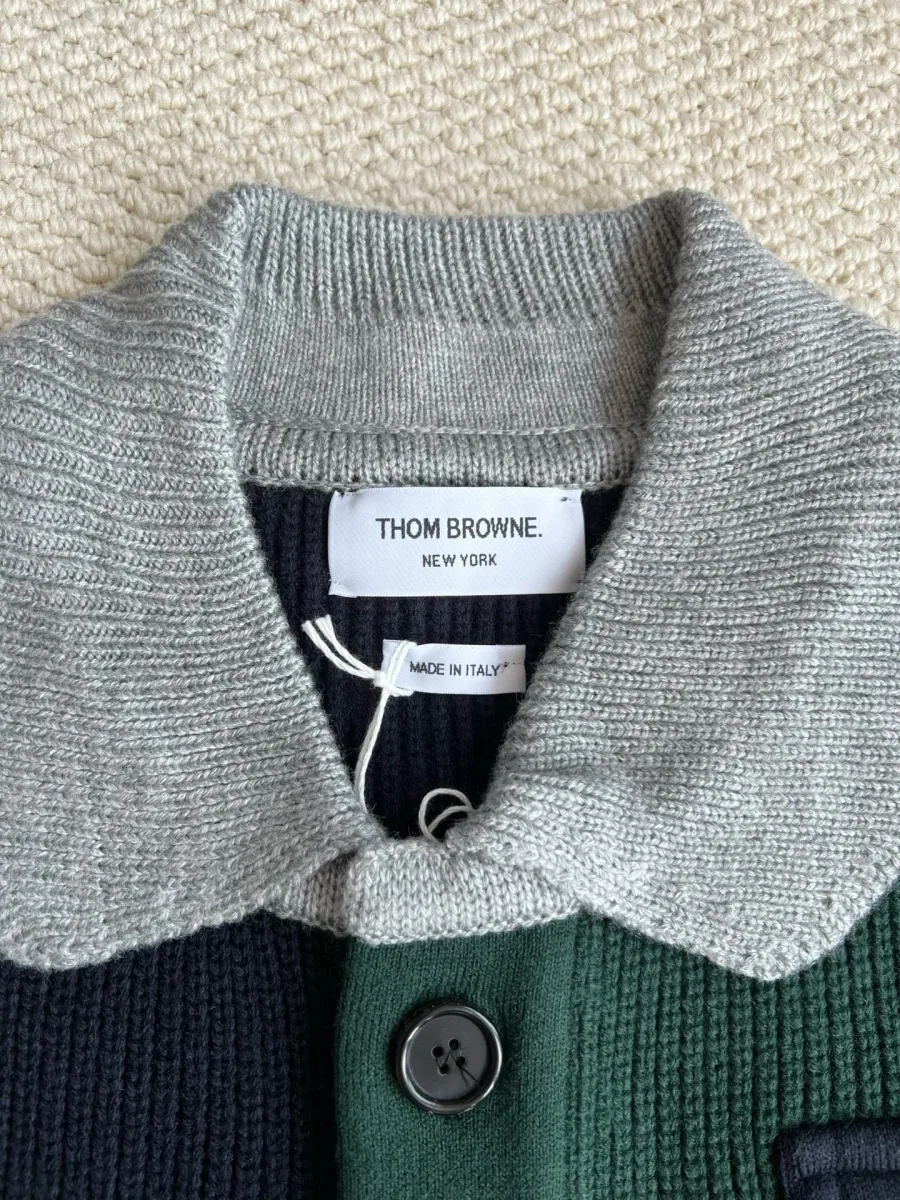 Крупный план серого вязаного воротника и ярлыка Thom Browne