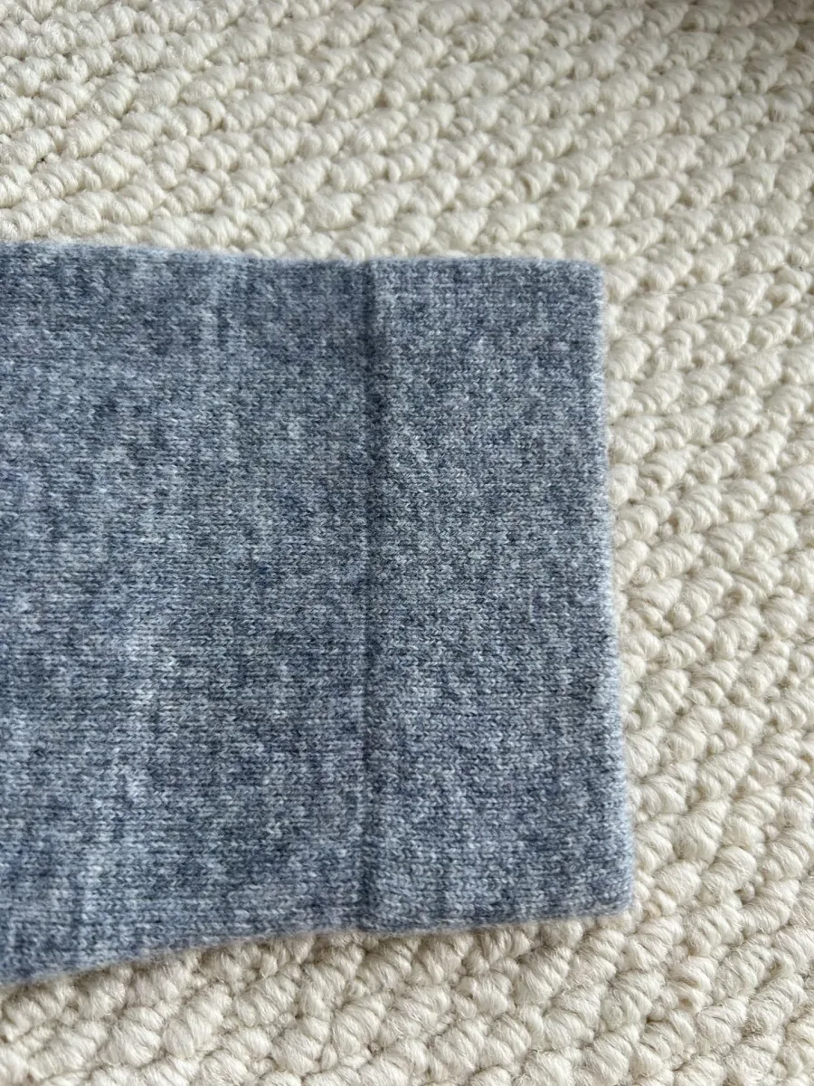 Манжета длинного рукава серого трикотажного кардигана крупным планом