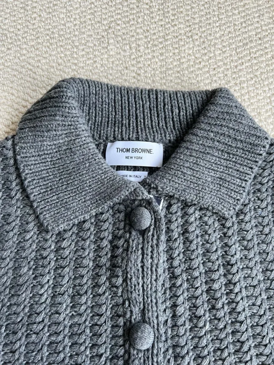 Отложной воротник и фирменная тканевая бирка Thom Browne крупным планом