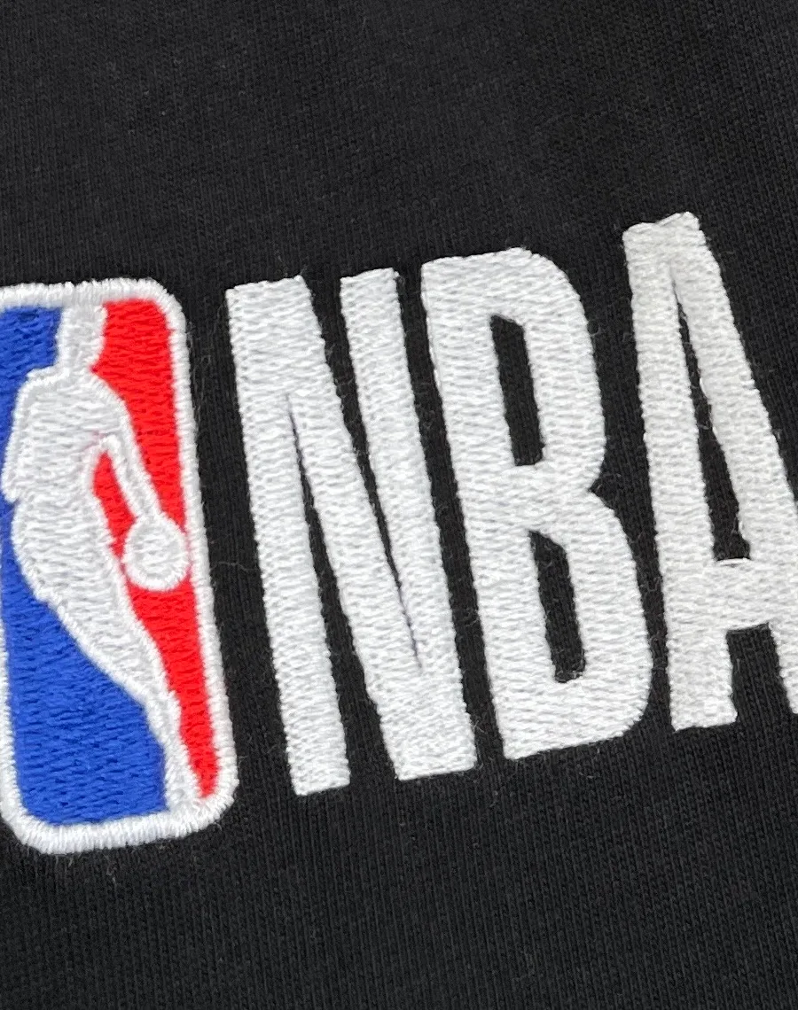 Вышитая цветная эмблема NBA на чёрной ткани шорт крупным планом
