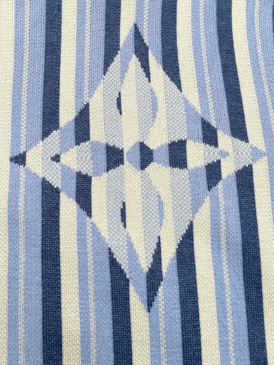 Крупный план жаккардового узора Monogram Flower на спинке кардигана