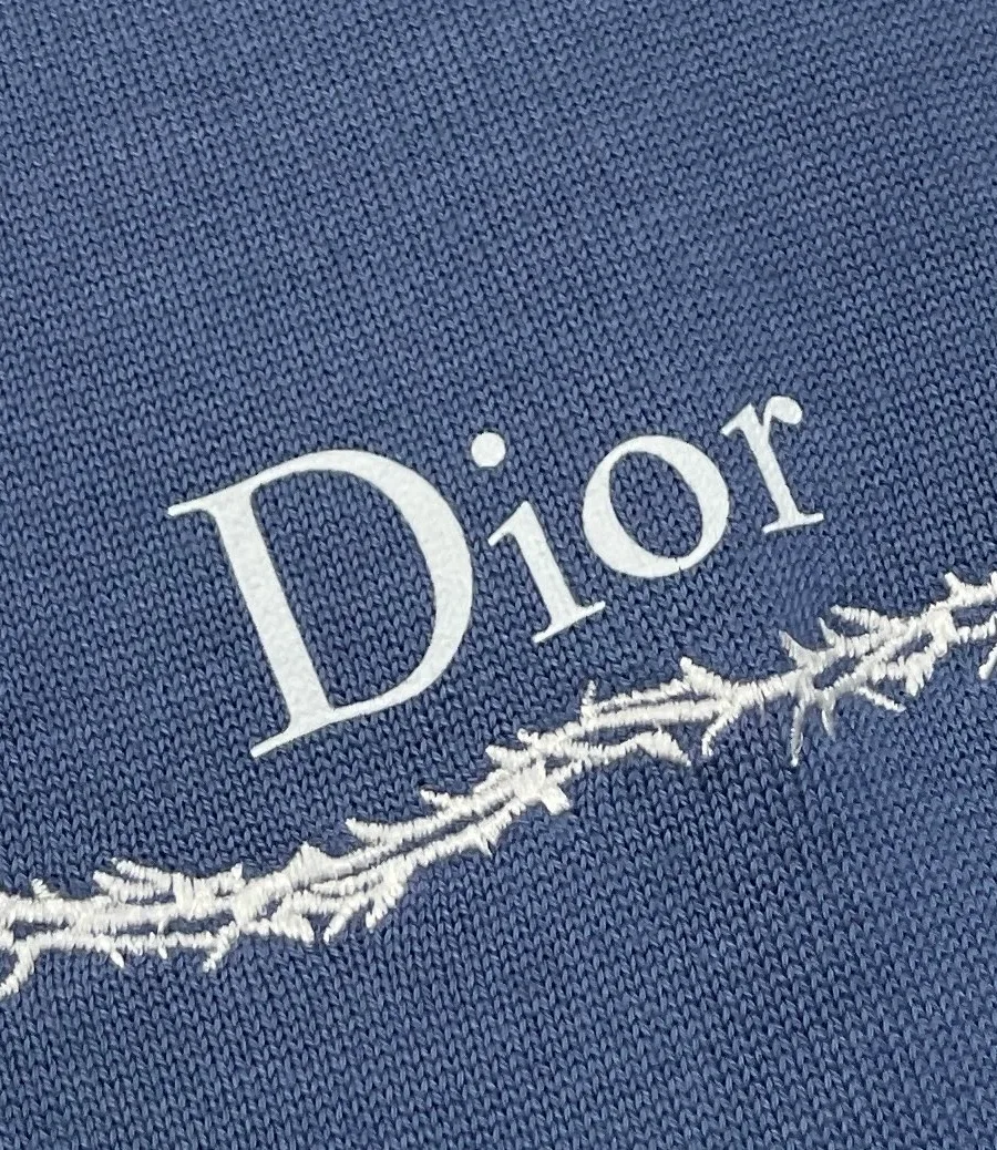 Крупный план надписи Dior и орнамента на синем трикотаже