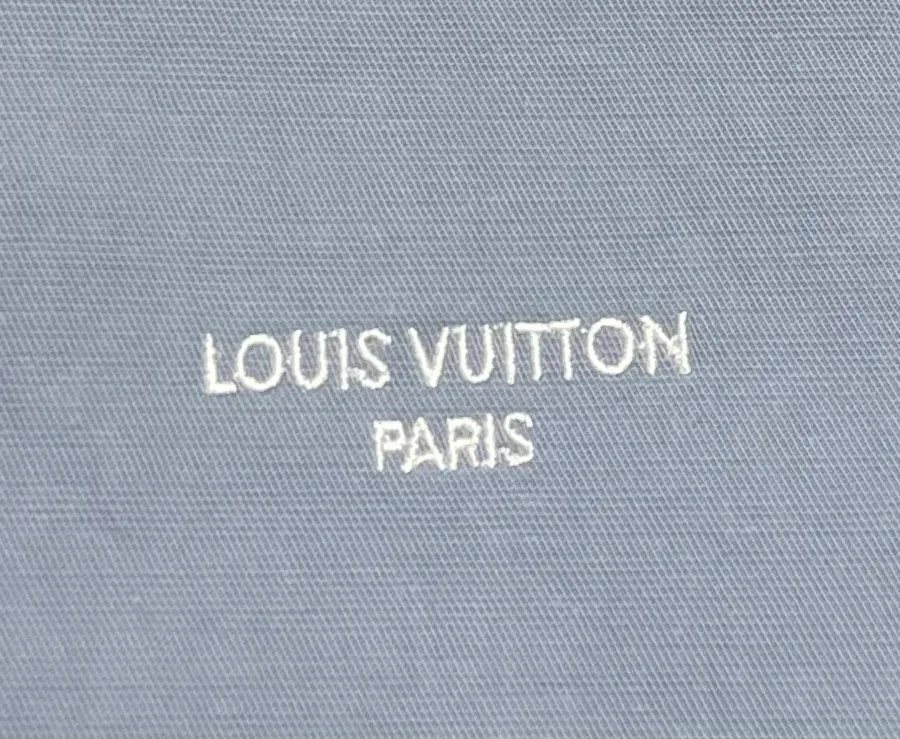 Вышитая светлыми нитями надпись Louis Vuitton Paris на груди