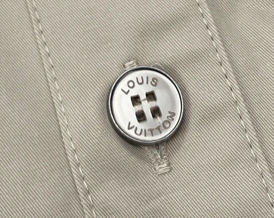 Светлая пуговица с гравировкой Louis Vuitton, макросъёмка