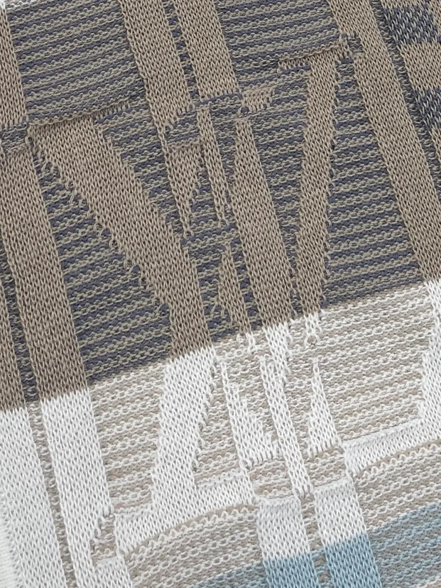 Крупный план жаккардовой вязки с мотивом Damier и монограммой бренда