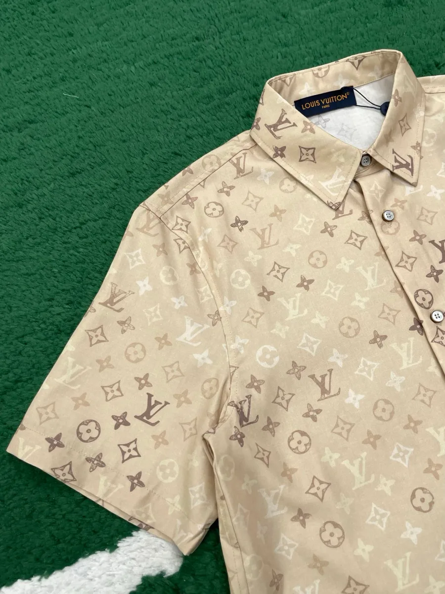 Плечо и короткий рукав бежевой рубашки с узором Monogram
