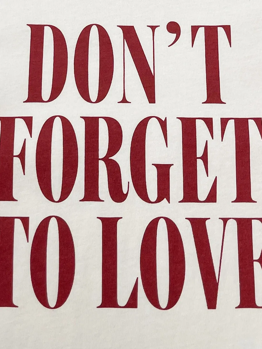 Крупный план бордового текстового принта Don't Forget To Love на груди