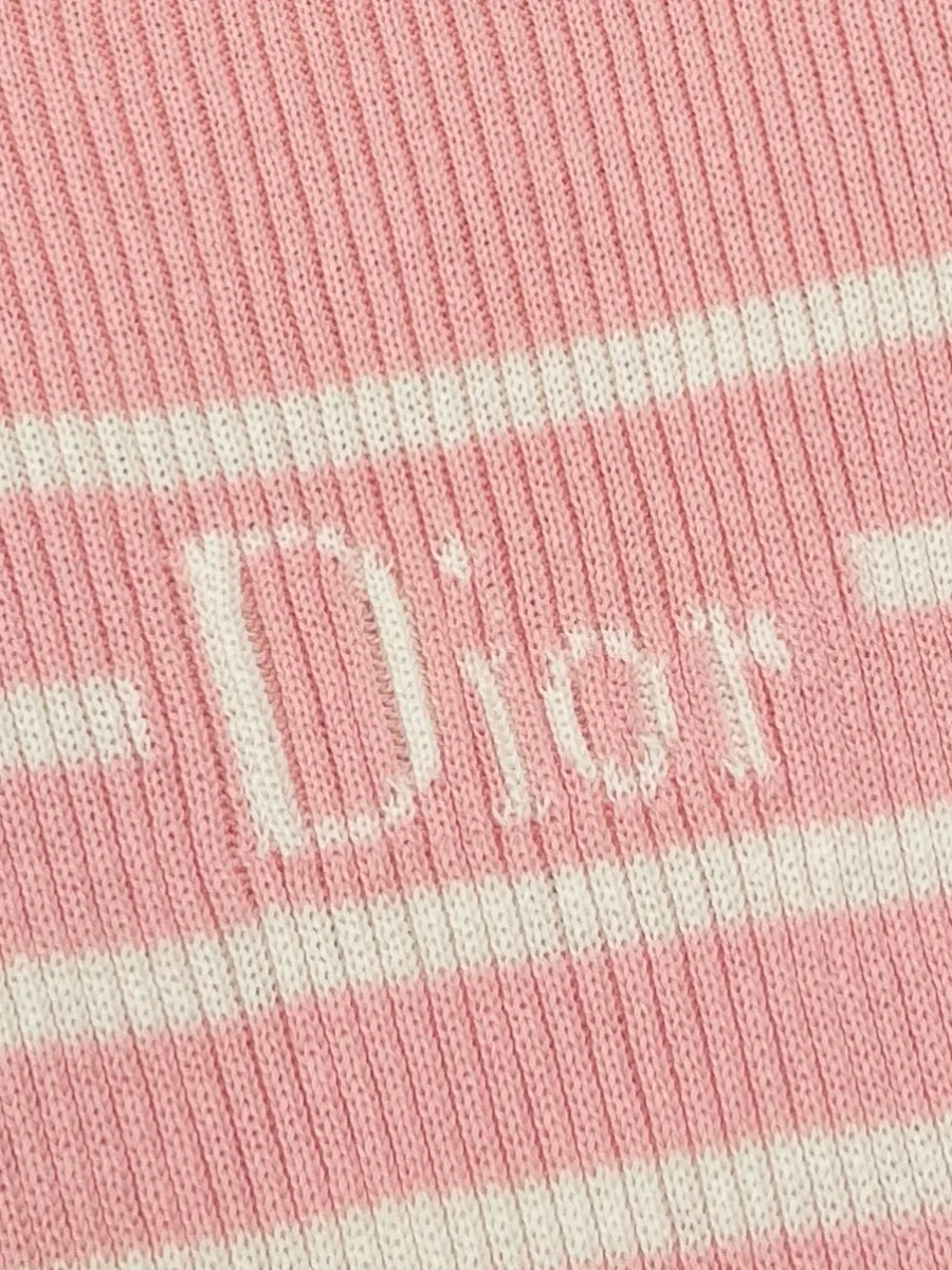Деталь груди с контрастной надписью Dior на фоне белой полосы