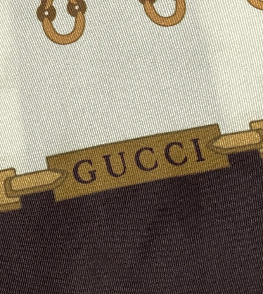 Фрагмент принта с надписью Gucci и геометрическим рисунком Horsebit