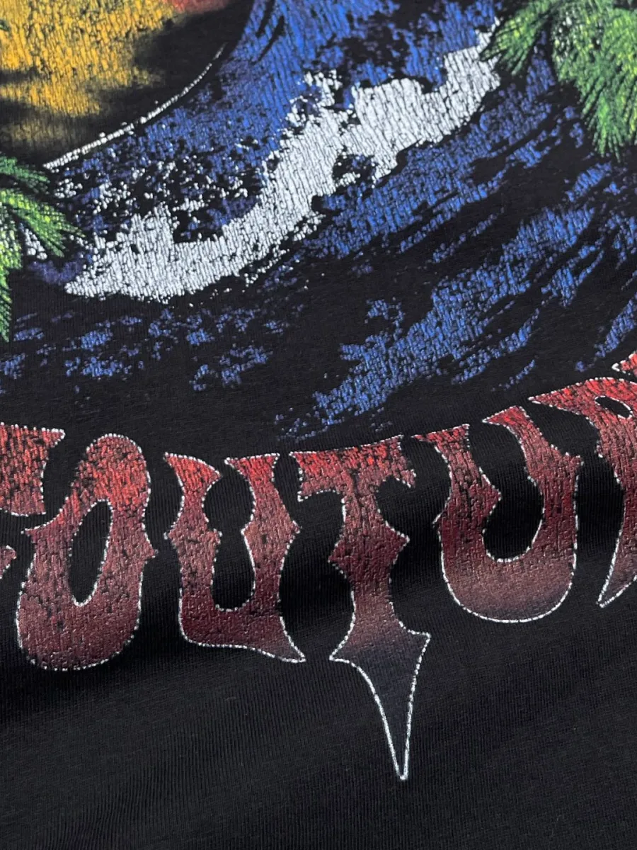 Деталь контрастного выцветшего принта с надписью Couture на чёрном фоне