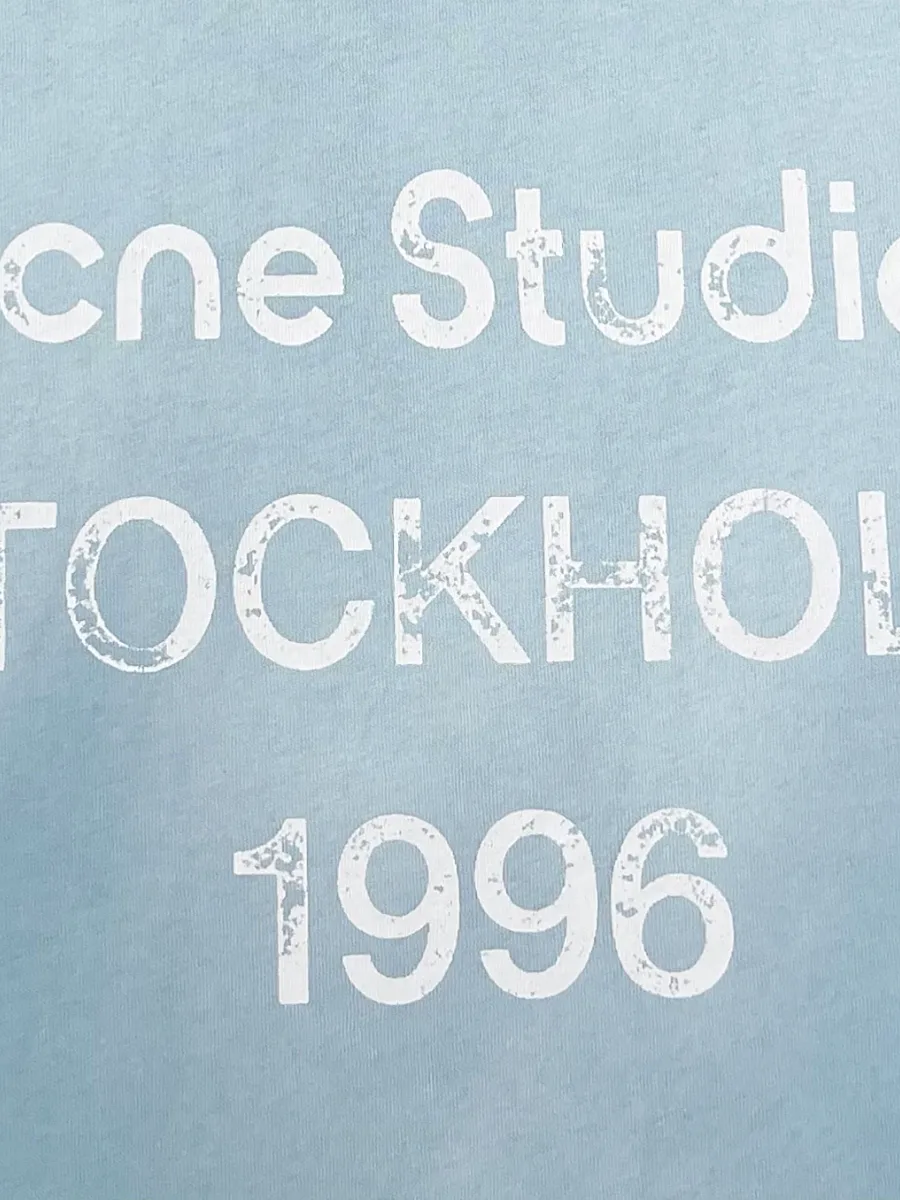 Белый фактурный принт с логотипом бренда и надписью Stockholm 1996 крупным планом