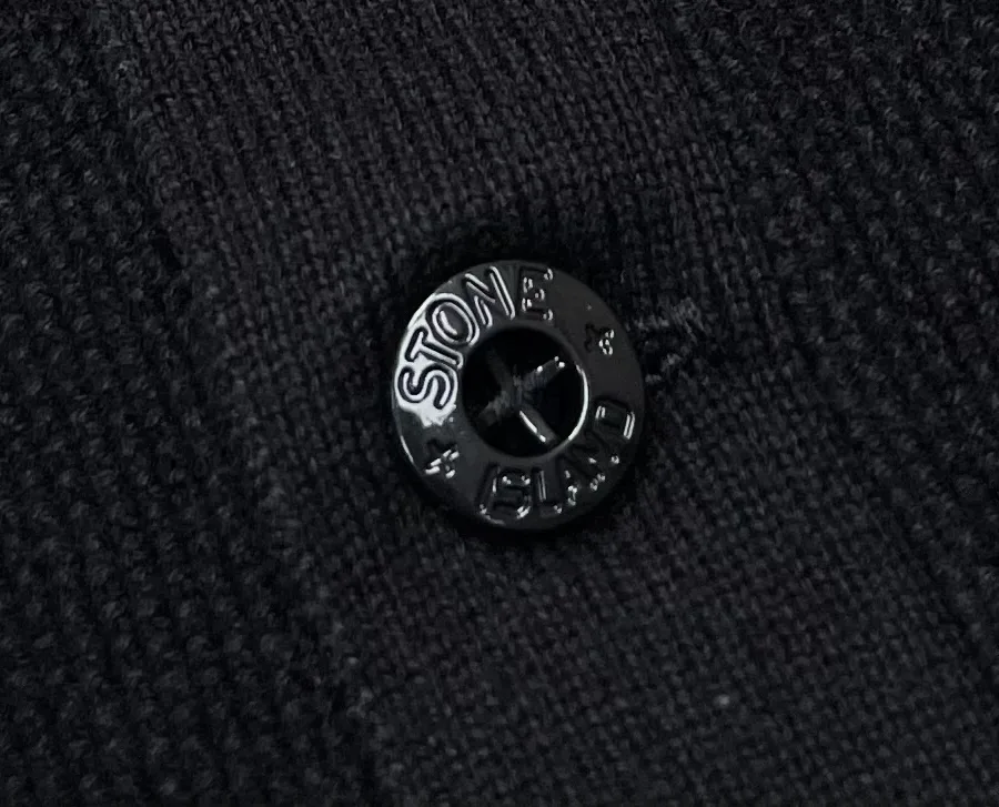 Макросъёмка чёрной пуговицы с круговой гравировкой Stone Island