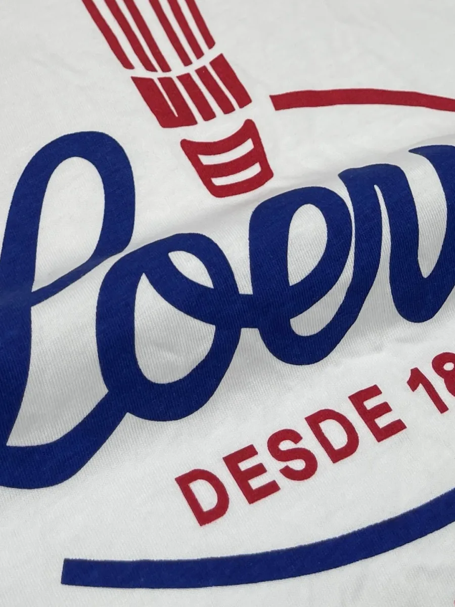Деталь принта с синей надписью Loewe и красной Desde 1846 Madrid