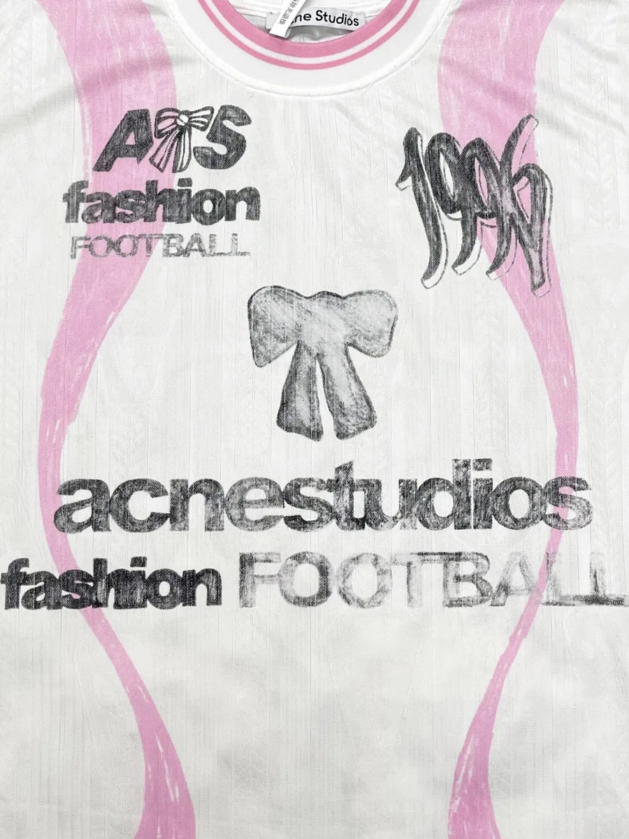 Принт с надписью acnestudios fashion football и бантом на груди лонгслива