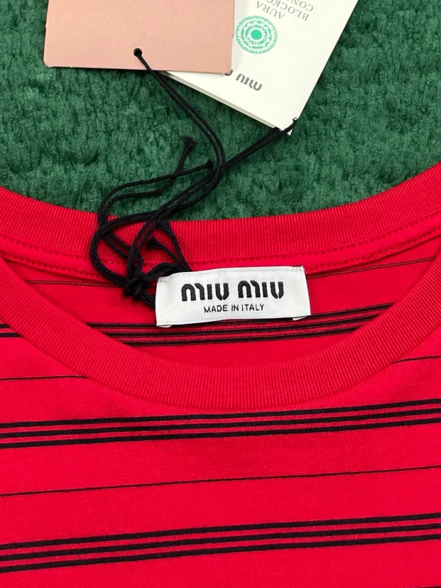 Круглая горловина красного лонгслива с биркой Miu Miu крупным планом