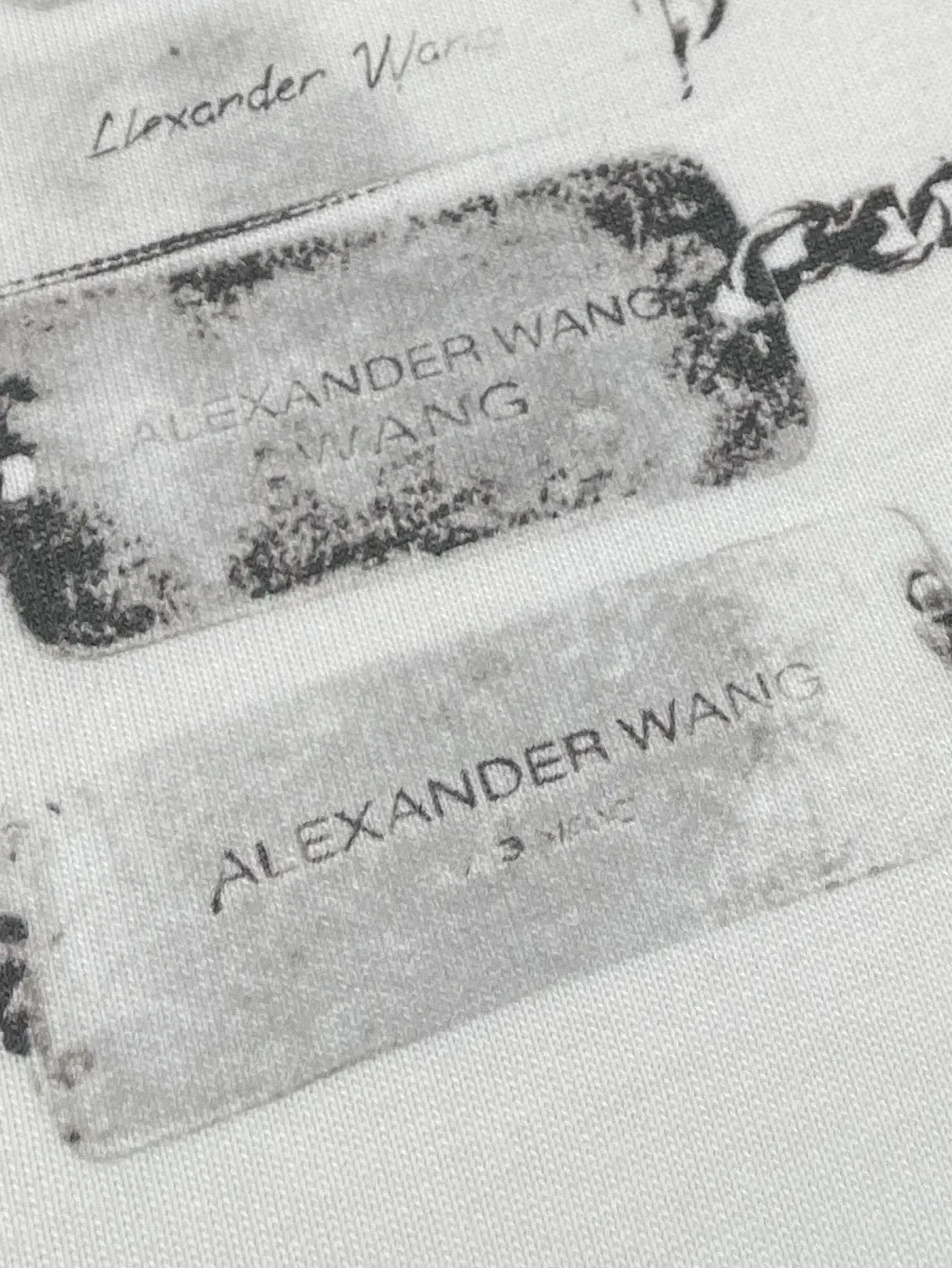 Крупный план принта с металлическими жетонами и логотипом Alexander Wang
