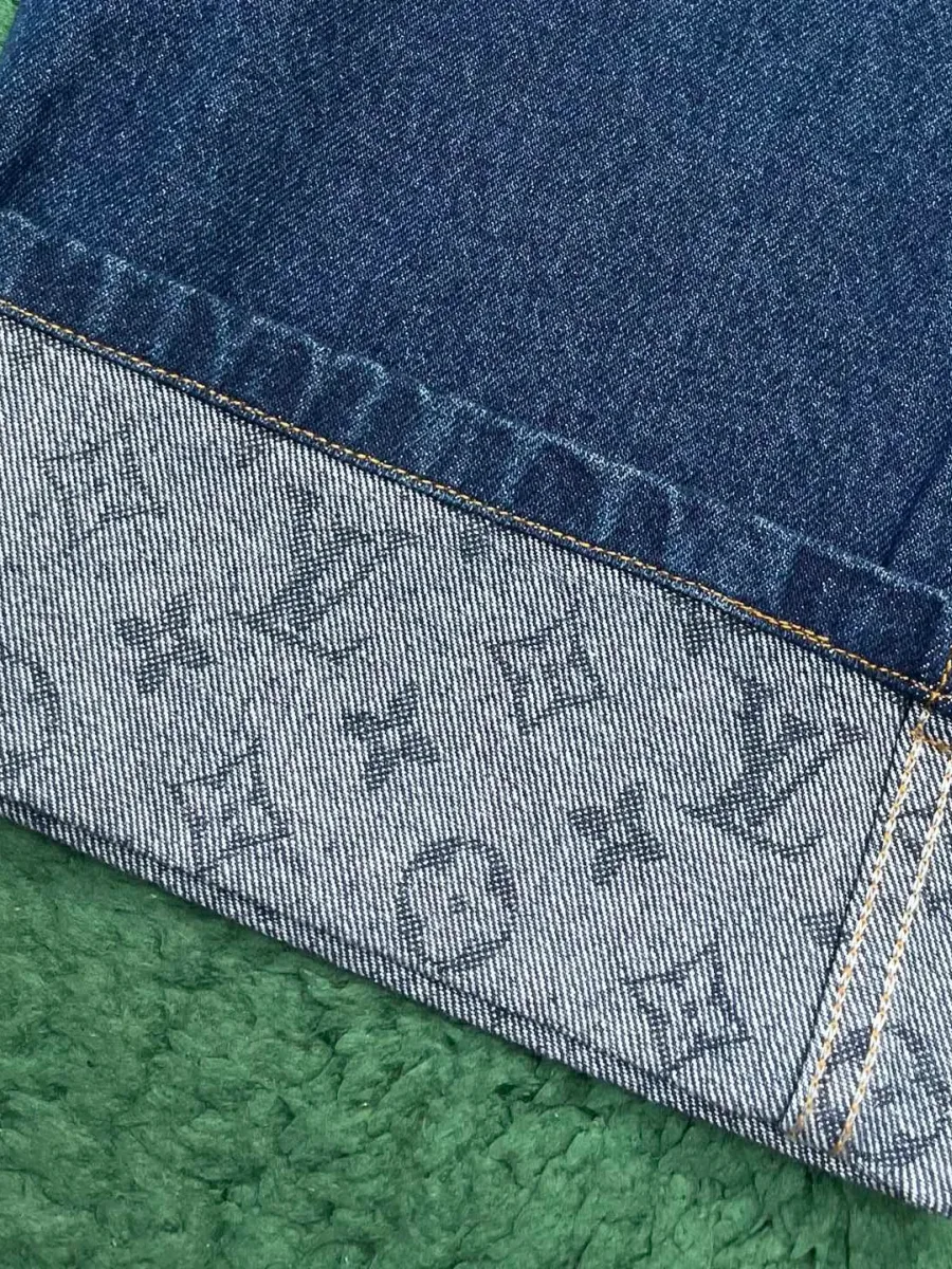 Крупный план отворота штанины с узором Monogram и двойной строчкой