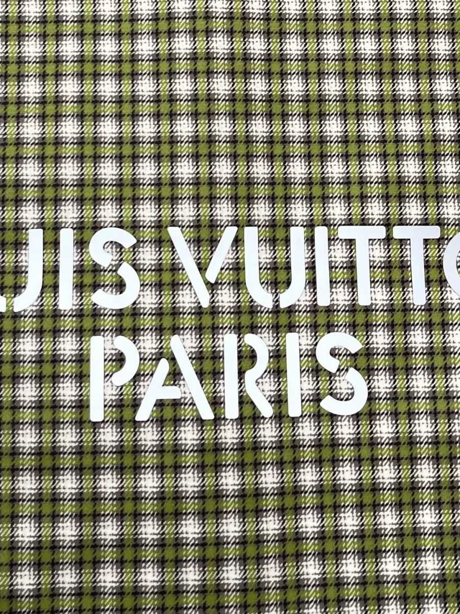 Белая надпись Louis Vuitton Paris на клетчатой ткани спинки рубашки
