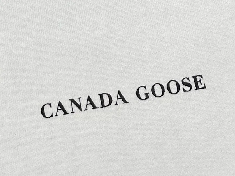 Крупный план аккуратного контрастного логотипа Canada Goose на груди
