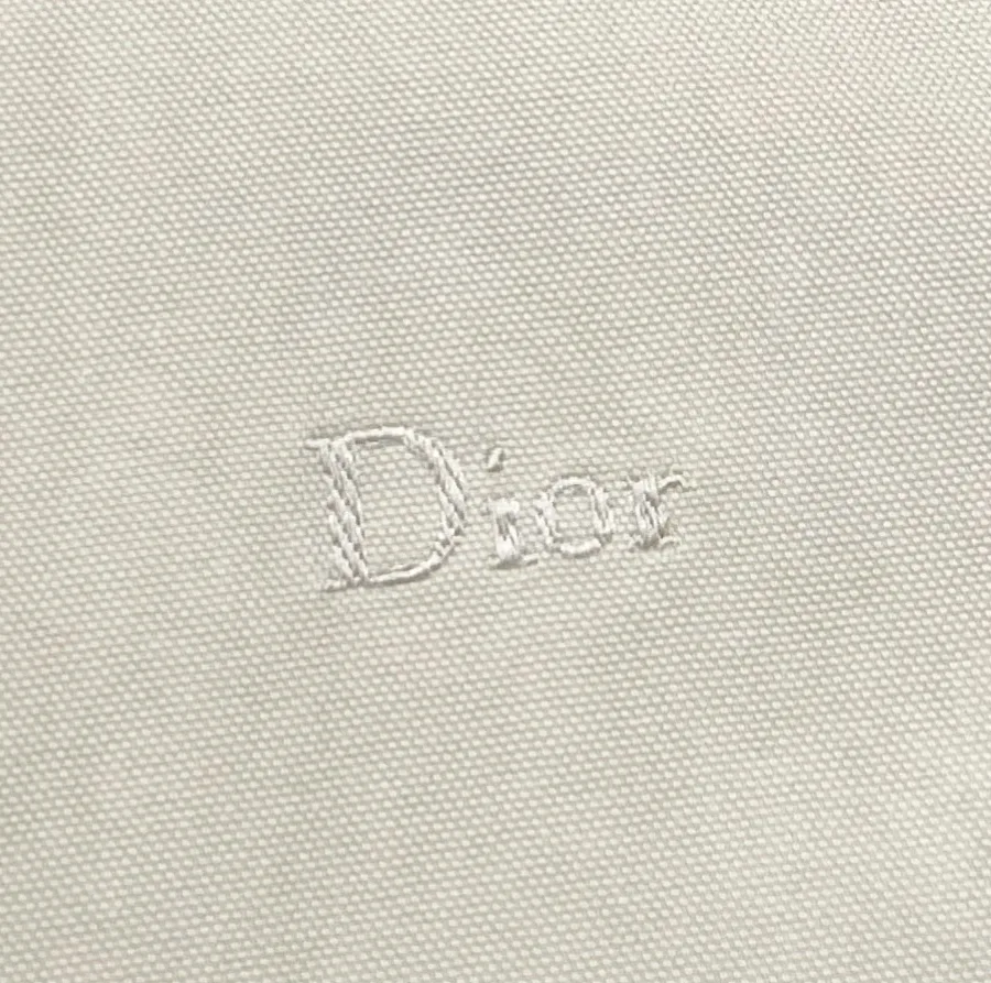 Фактура хлопкового материала куртки с вышитым логотипом Dior