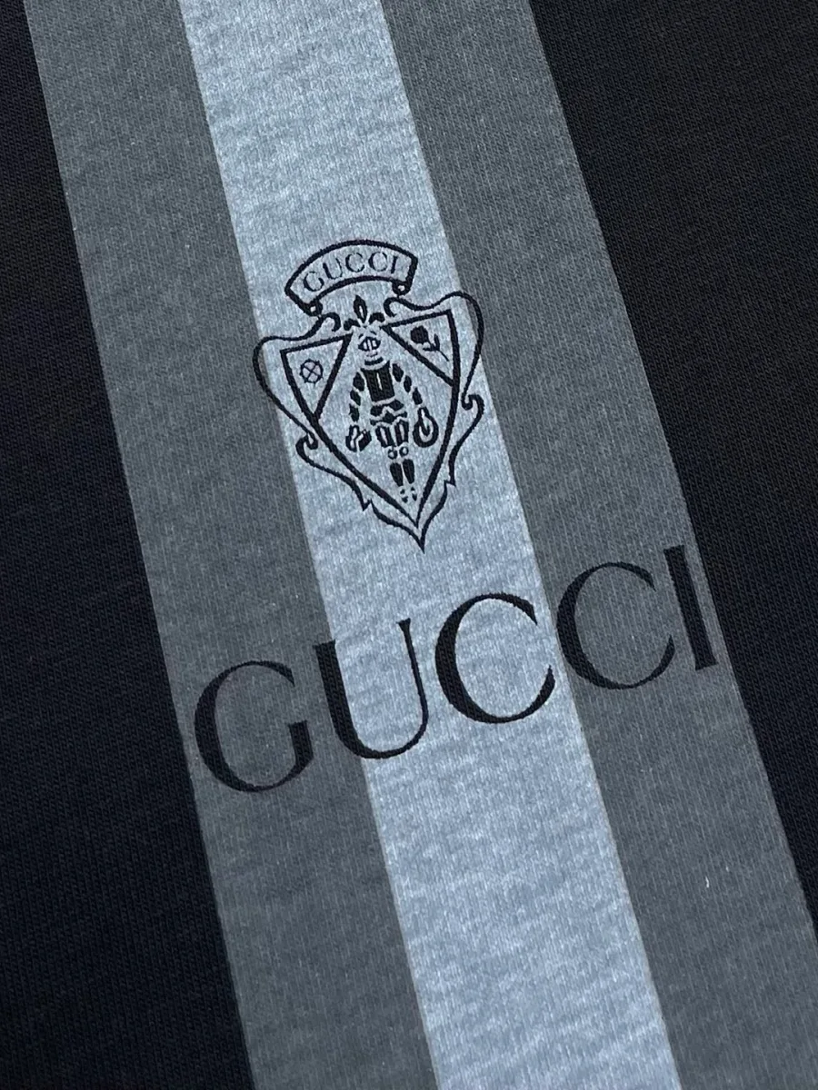 Крупный план контрастной полосы с гербом и принтом Gucci на груди