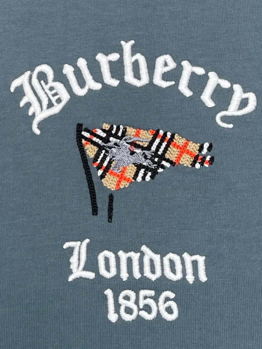 Крупный план вышивки с надписью Burberry London 1856 и флажком