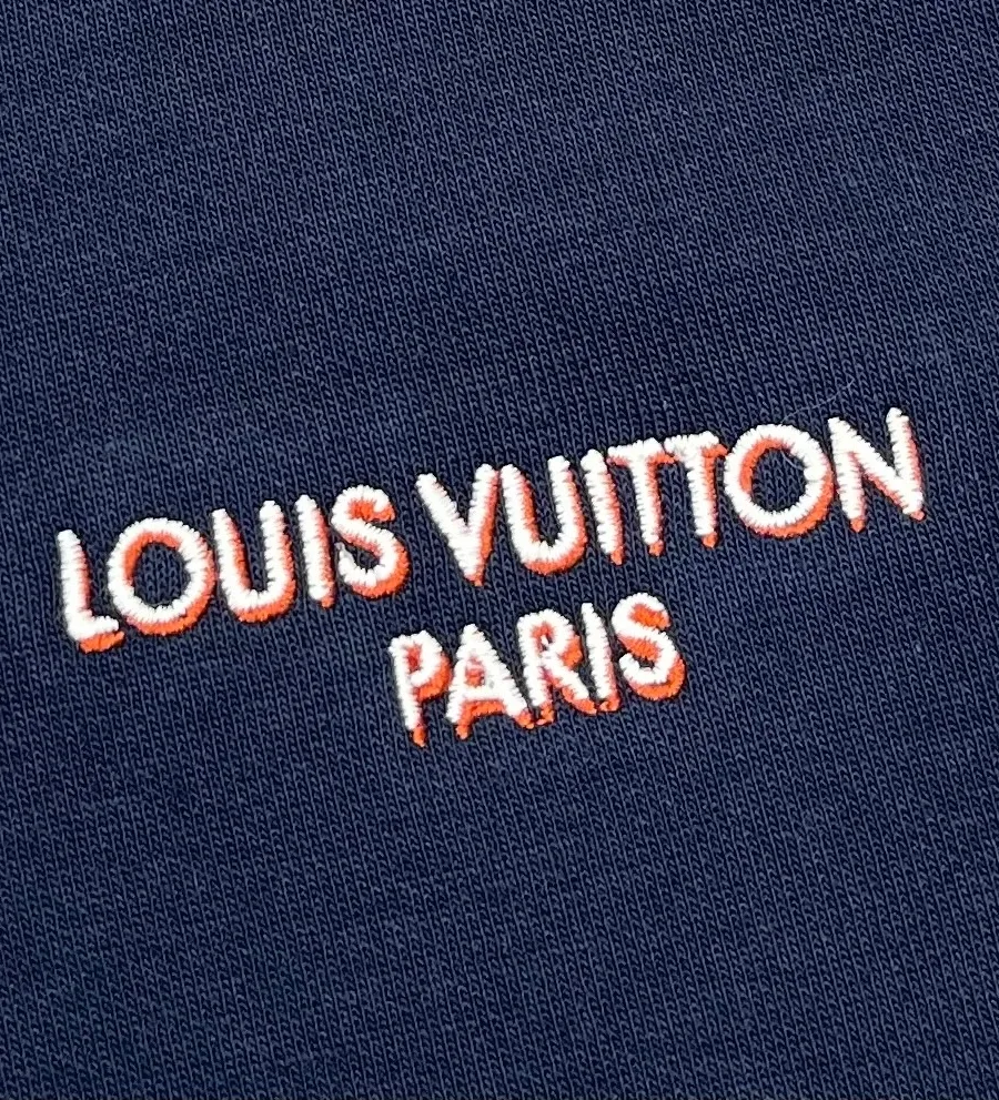 Крупный план контрастной вышивки Louis Vuitton Paris на груди бомбера