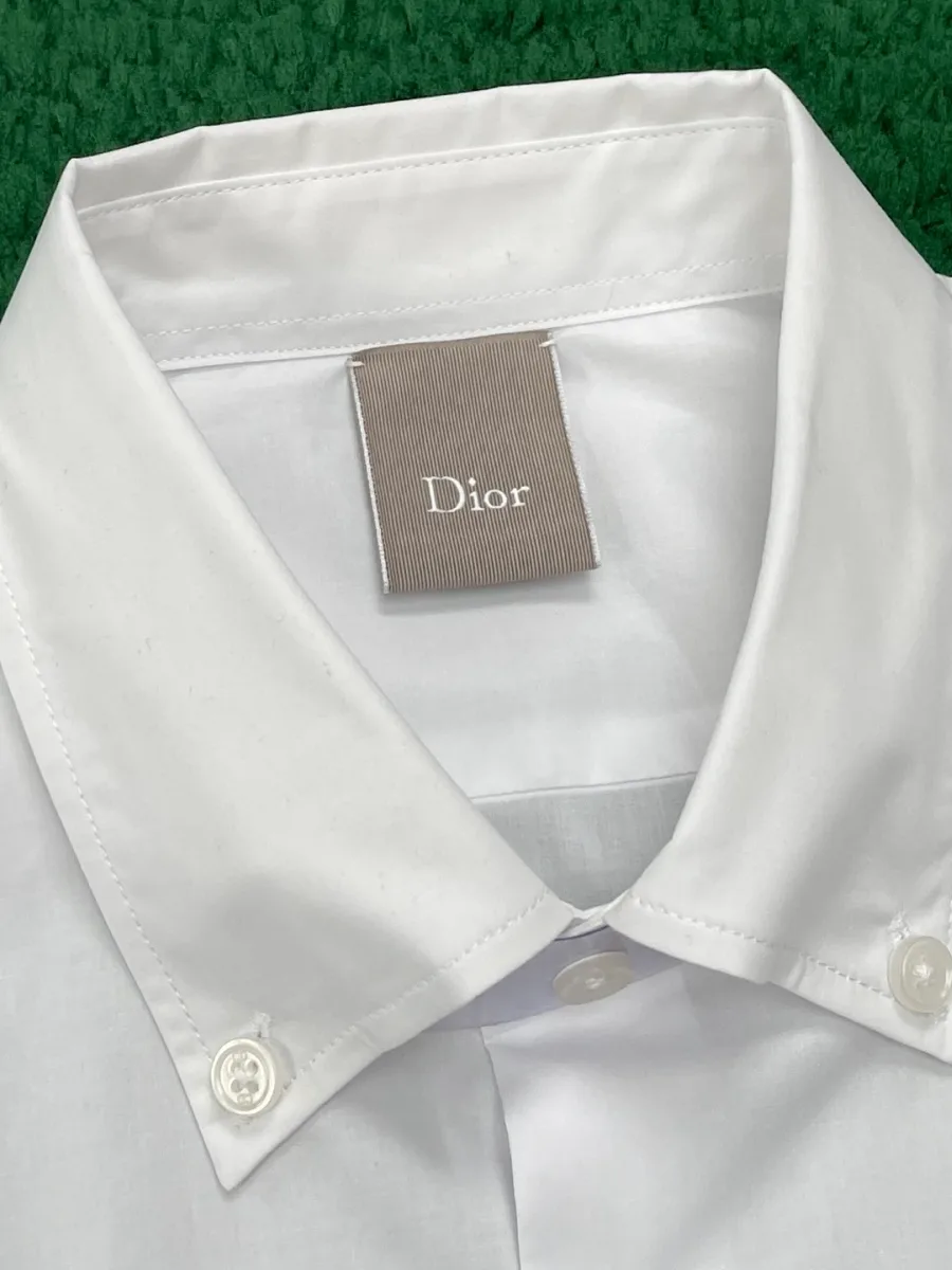 Воротник button-down белой рубашки с ярлыком бренда