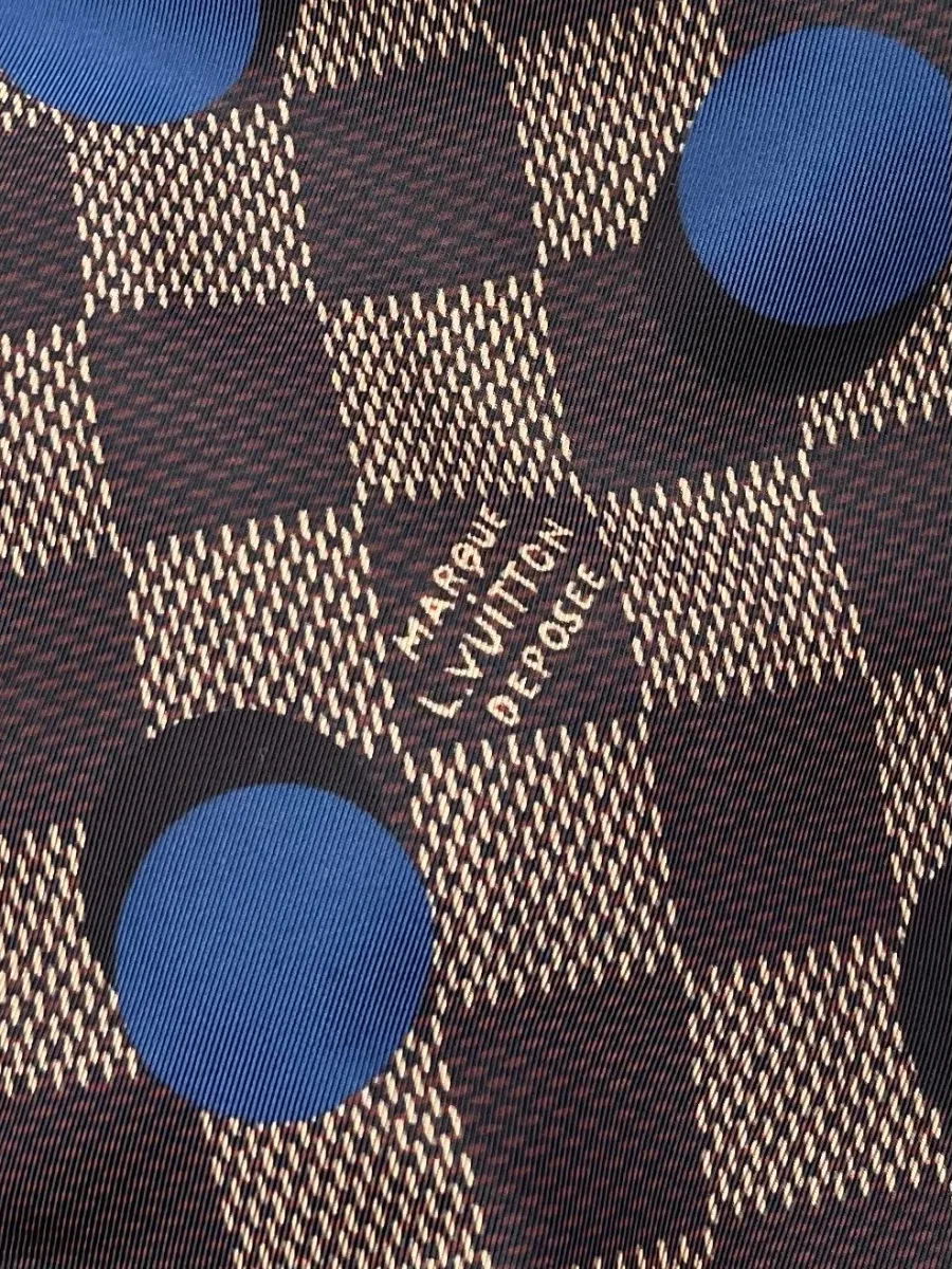 Крупный план ткани в клетку Damier с надписью Marque L.Vuitton Deposee