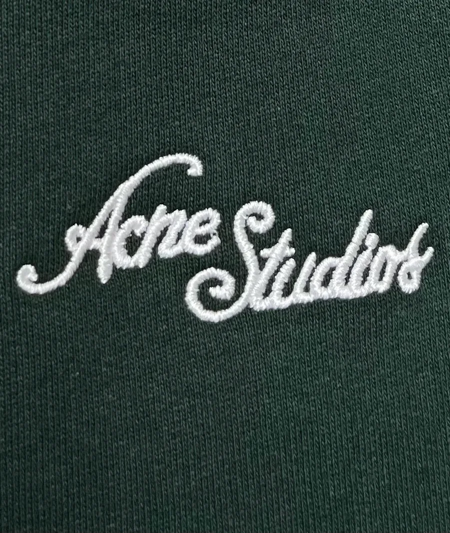 Контрастная белая вышивка логотипа Acne Studios крупным планом
