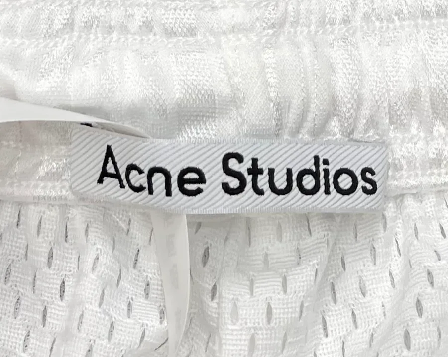 Фирменная бирка Acne Studios на сетчатой подкладке крупным планом