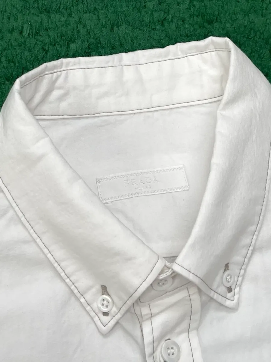 Воротник button-down белой рубашки и верхняя пуговичная планка